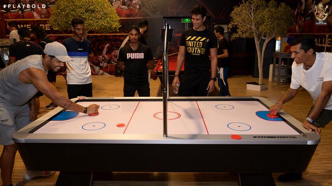 RCB teammates enjoying air hockey at the team recreation centre